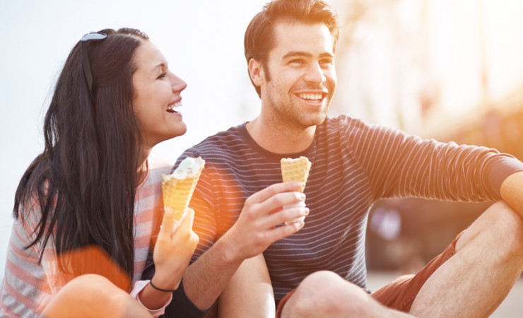 attractive young couple eating ice cream and laughing